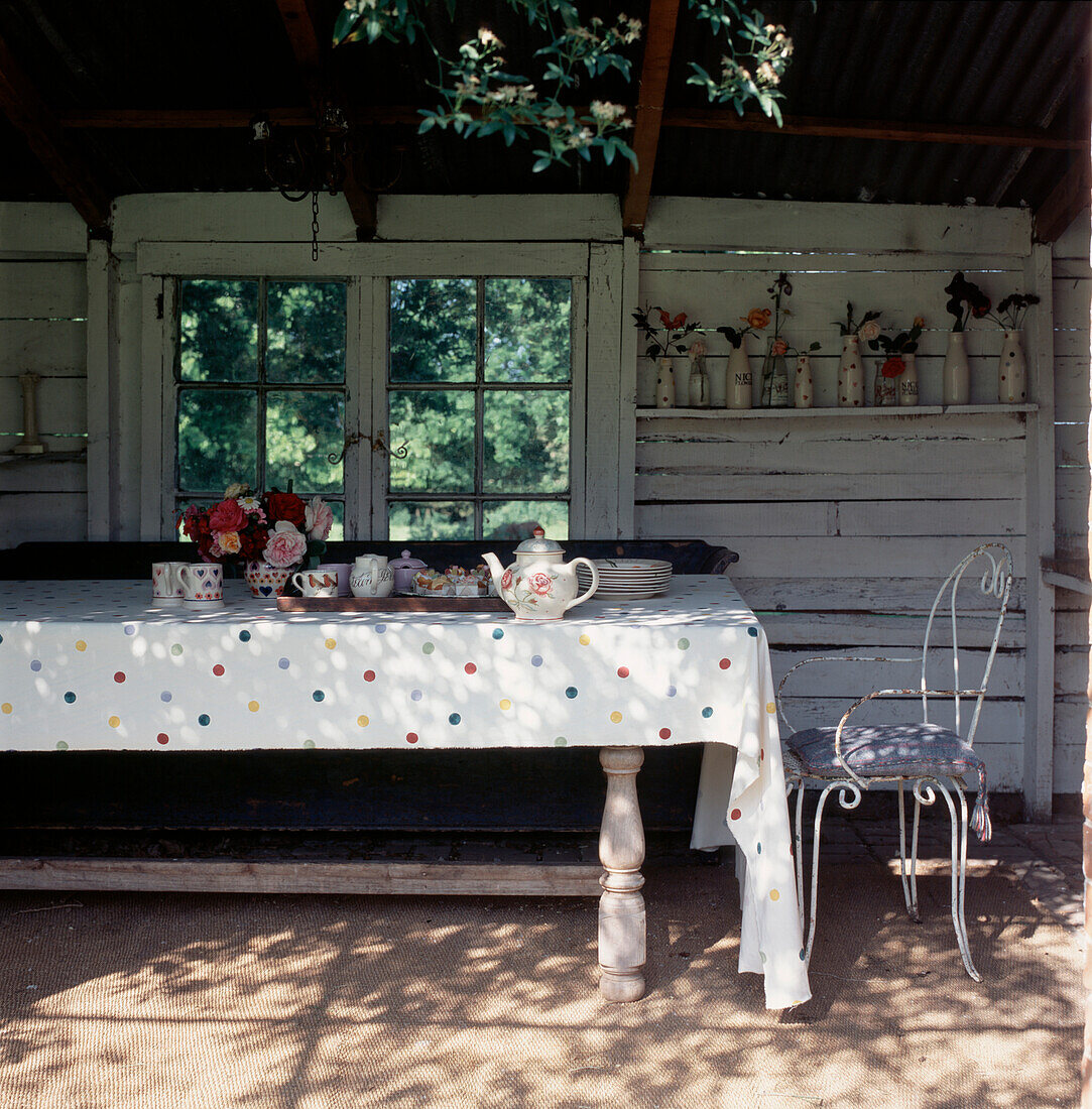 Garden summer house with large table set for afternoon tea