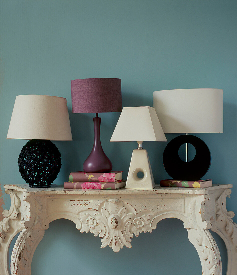 Ornate painted console table with collection of table lamps