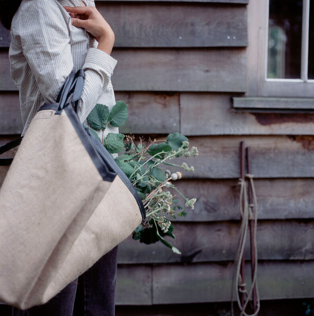 Woman removing garden waster in a canvas bag
