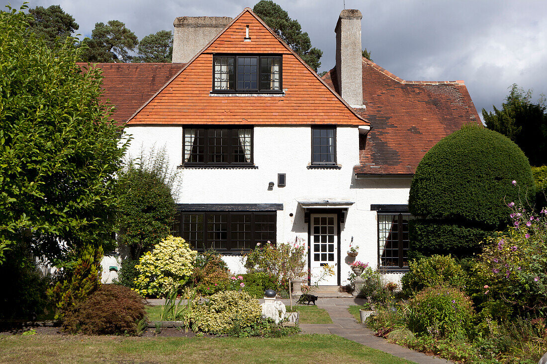 Front path and whitewashed exterior of detached Surrey home England UK