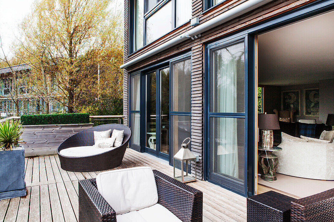 Wicker furniture on terrace exterior of lakeside home, England, UK