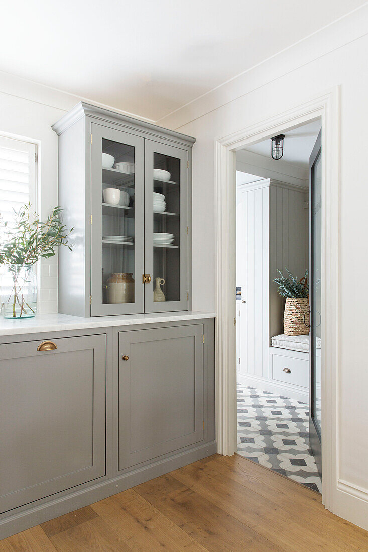 Light grey fitted units with view through doorway in London home UK