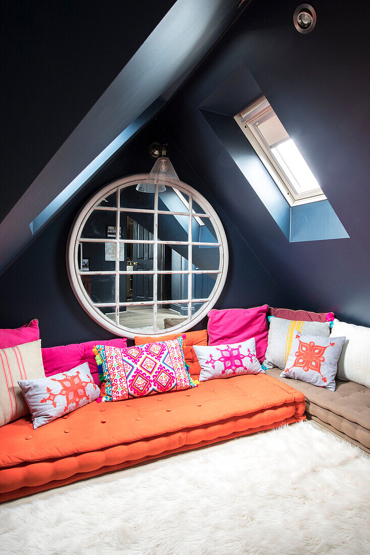 Large round wall mirror with embroidered curtains in attic conversion of Victorian terrace Wandsworth London Uk