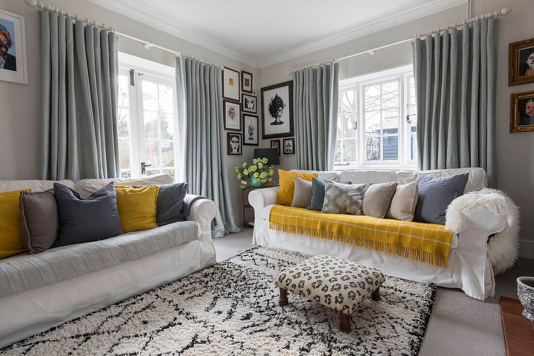 White sofas with grey and yellow soft furnishing in Guildford cottage Surrey UK