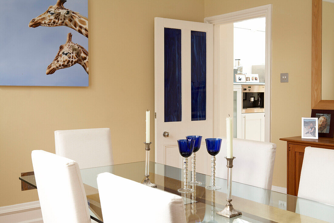 Giraffenköpfe auf Leinwand in einem modernen blau-weißen Esszimmer
