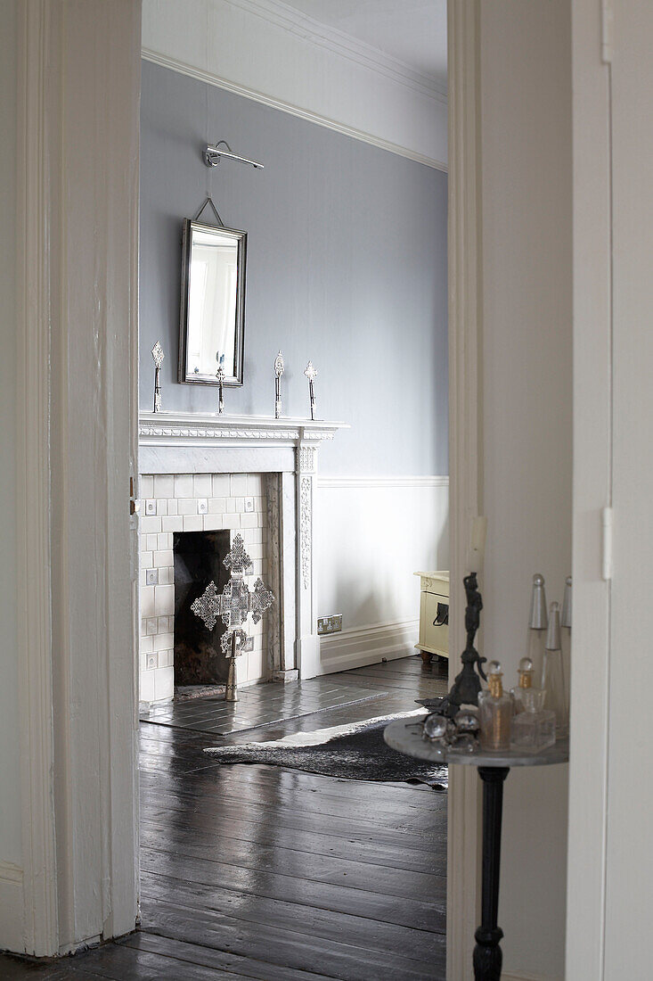 View through doorway to fireplace in sparsely furnished light blue room