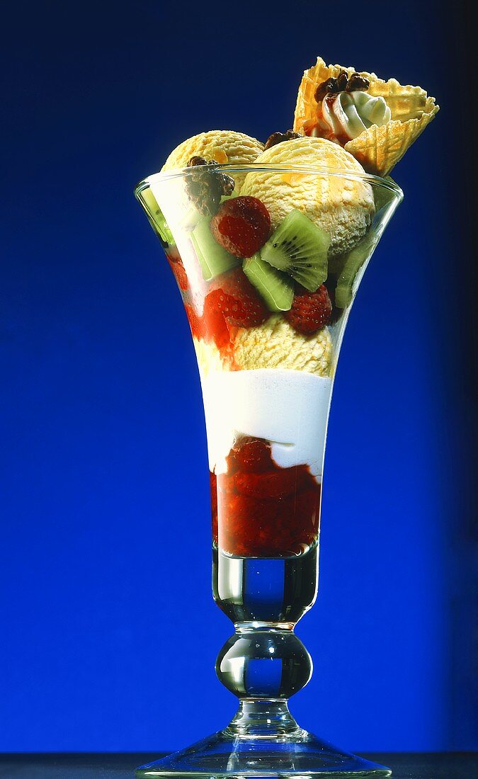 Eis mit Joghurt & Früchten in hohem Glas, garniert mit Waffel