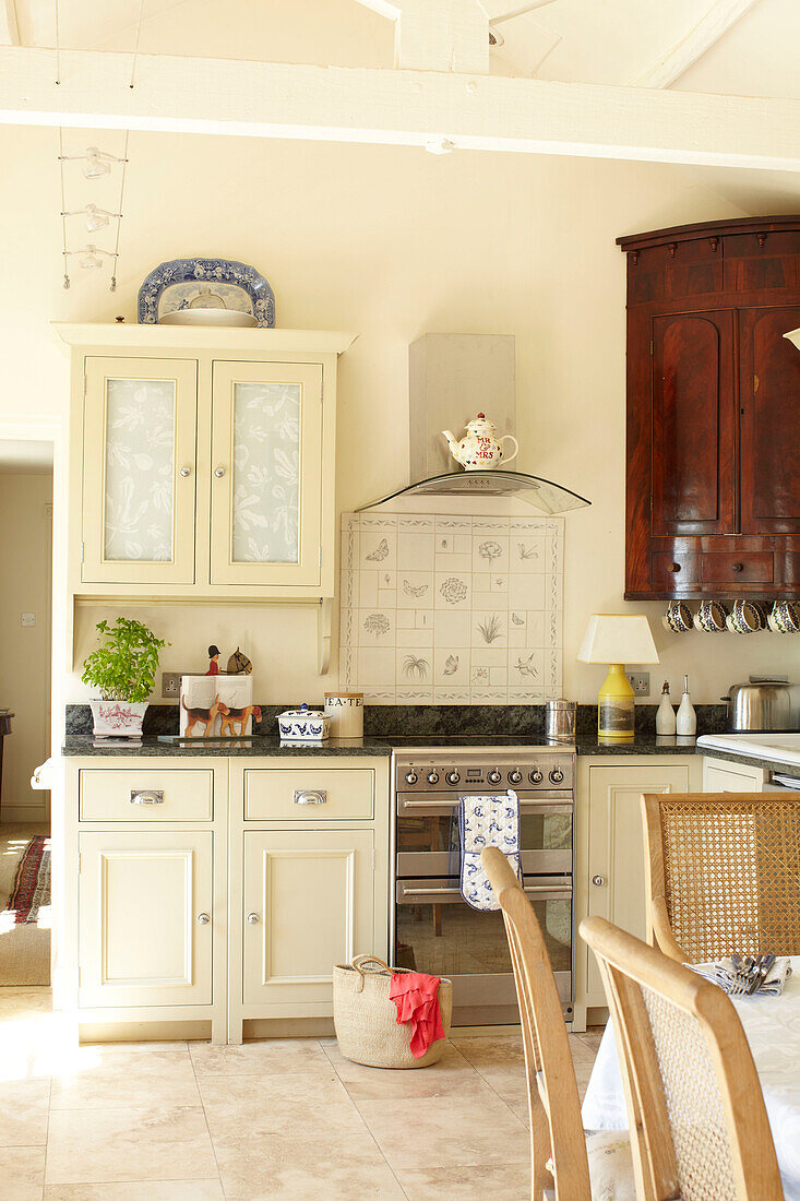 Cream fitted kitchen with stainless steel oven in Wiltshire country home, England, UK