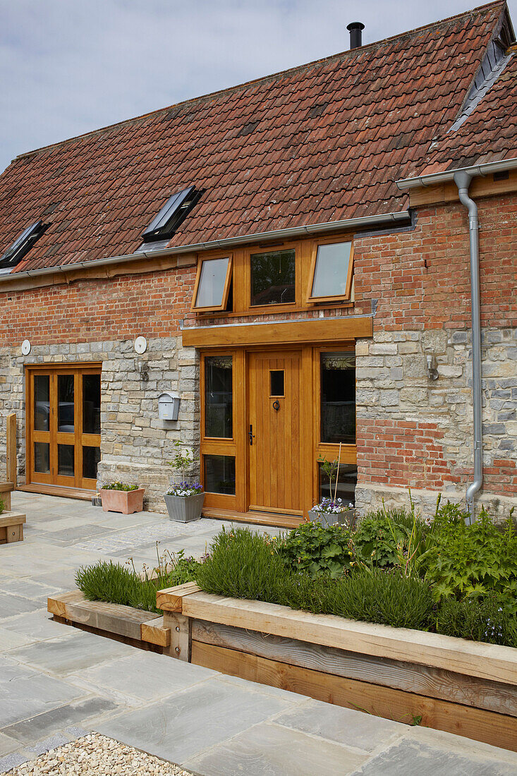 Außenfassade einer umgebauten Scheune in Somerset aus Ziegeln und Stein, England, UK