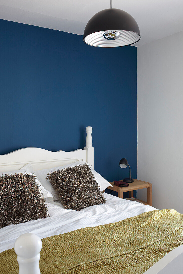 Mustard blanket and blue feature wall in contemporary Weymouth bedroom, Dorset, UK