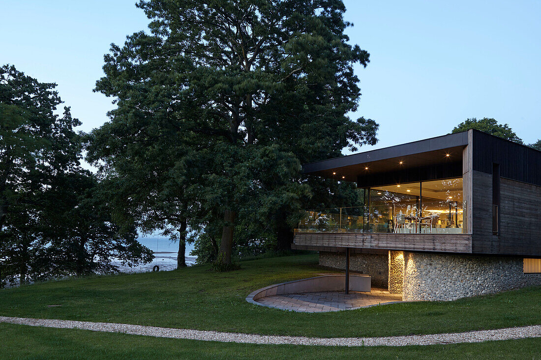 Lit modern facade with timber cladding and pebble-dashed lower storey Isle of Wight, UK