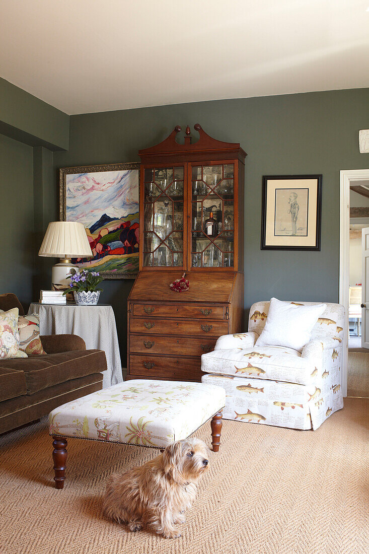 Fish patterned armchair with ottoman footstool in living room of Wiltshire home, England, UK