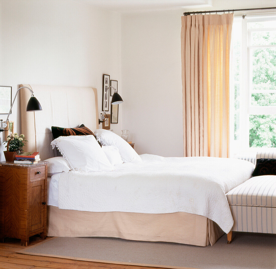 White bedroom with double bed and upholstered headboard