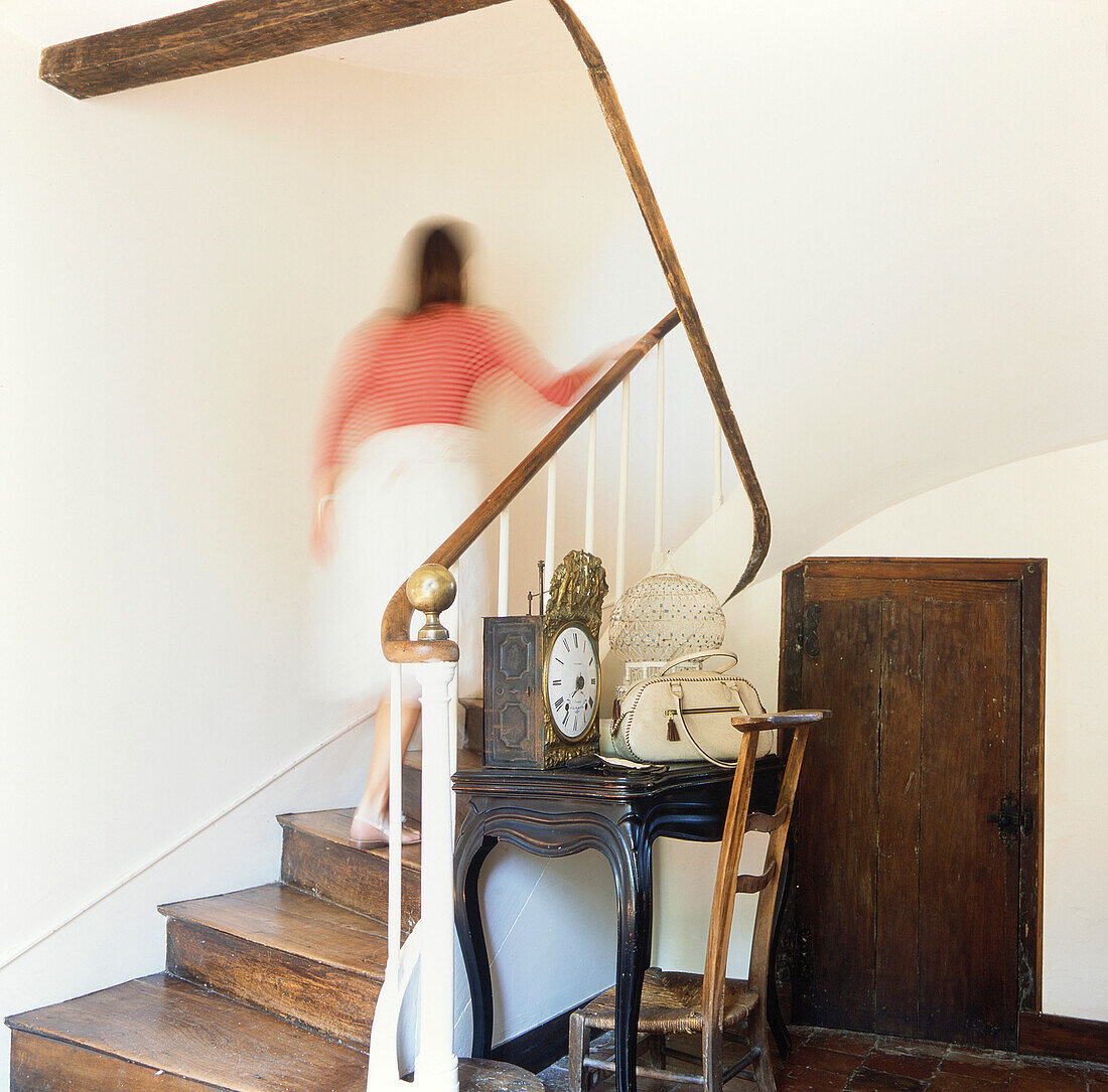 Wooden staircase with antique wooden furniture with woman