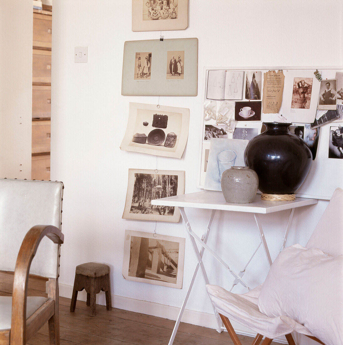 Auslage mit Schwarz-Weiß-Fotografien und Postkarten an einer Wand neben einem Klapptisch mit Töpfen
