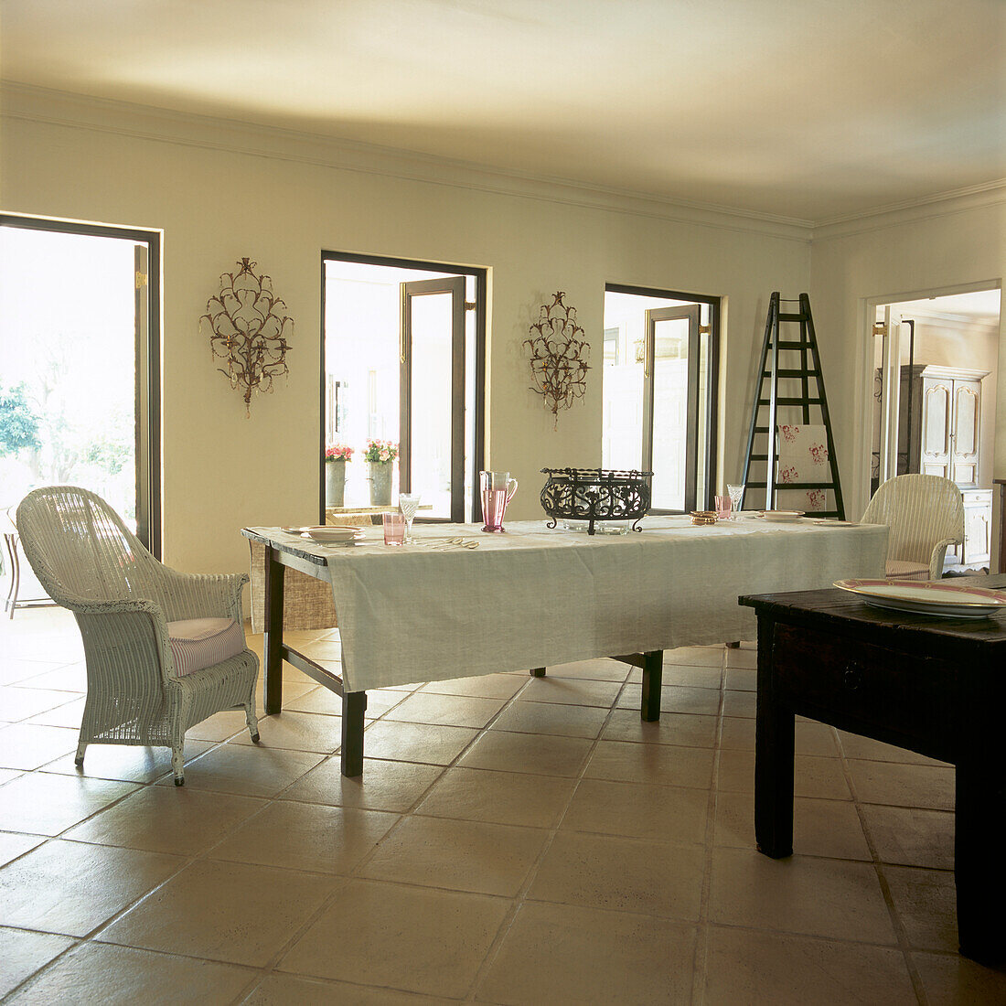 Dining room with long dining table covered in vintage linen