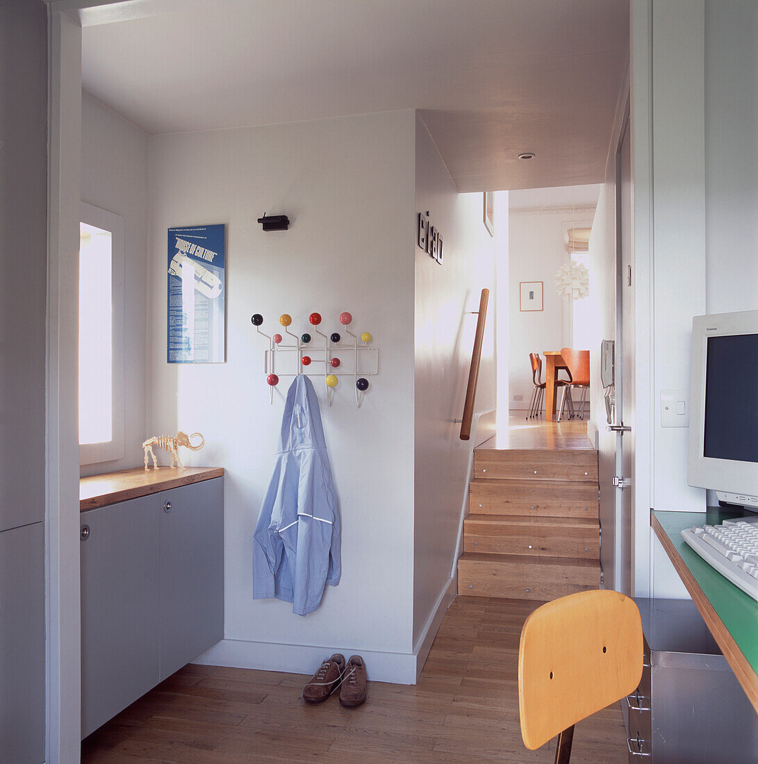 Teenager's bedroom with desk and computer and stairs leading to dining room