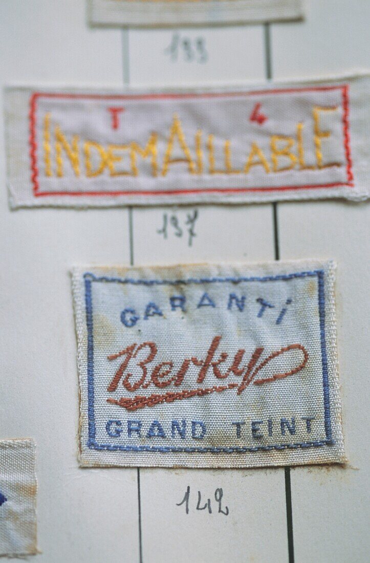 Close up of an album of vintage machine embroidered clothing labels 
