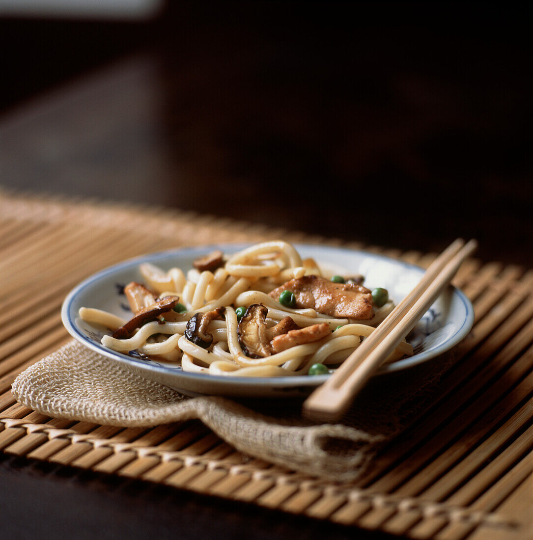 Udon noodle dish with ginger chicken shiitake mushrooms and peas