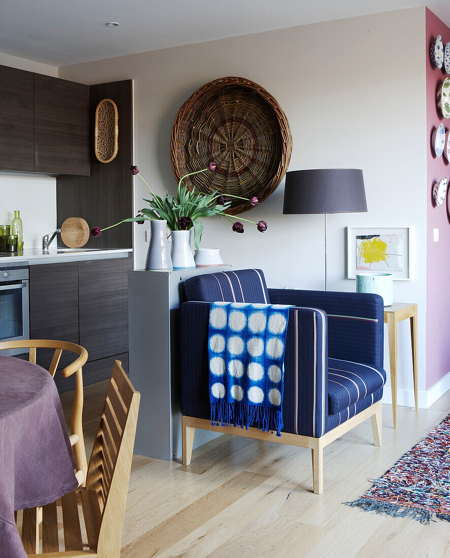 Open plan kitchen dining and living space with large willow basket and tulips in vases