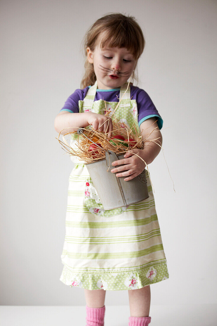 Young girl with bucket of multi-coloured Easter Eggs