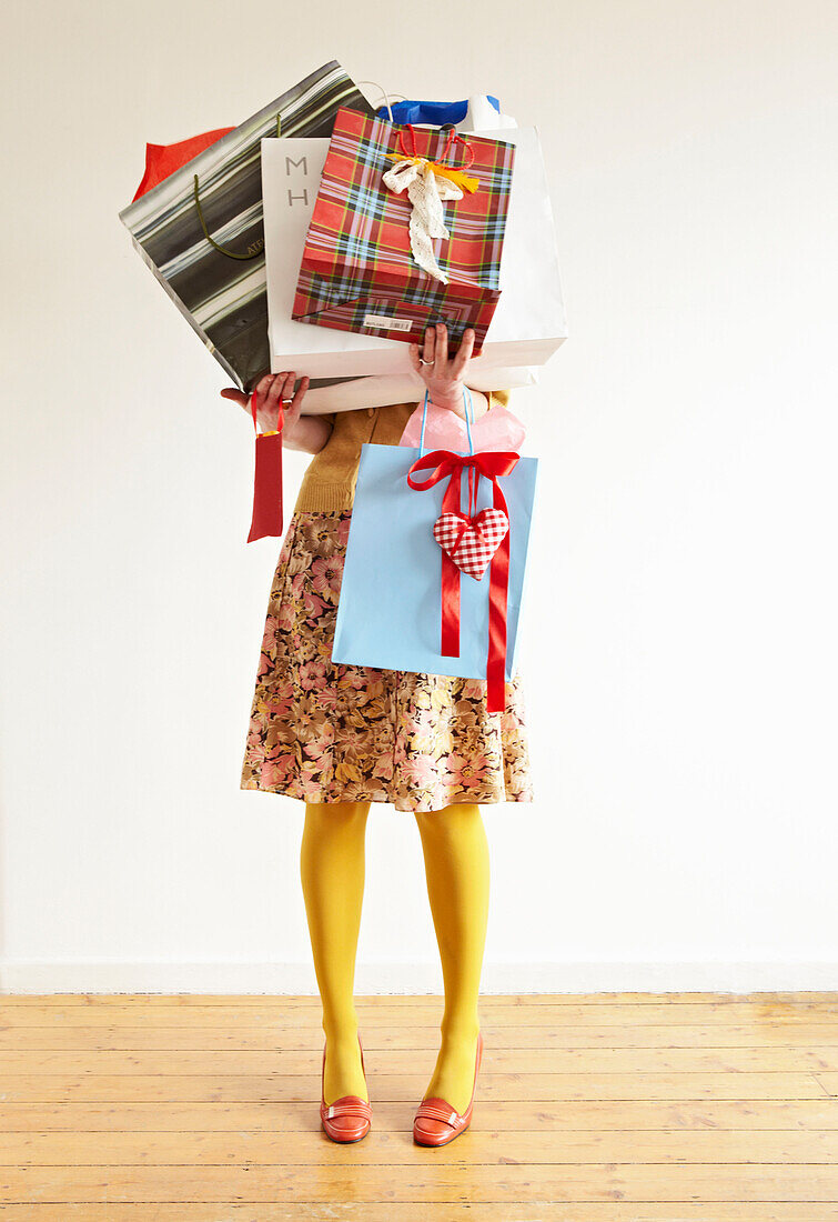 Woman holds an assortment of gift wrapped shopping bags