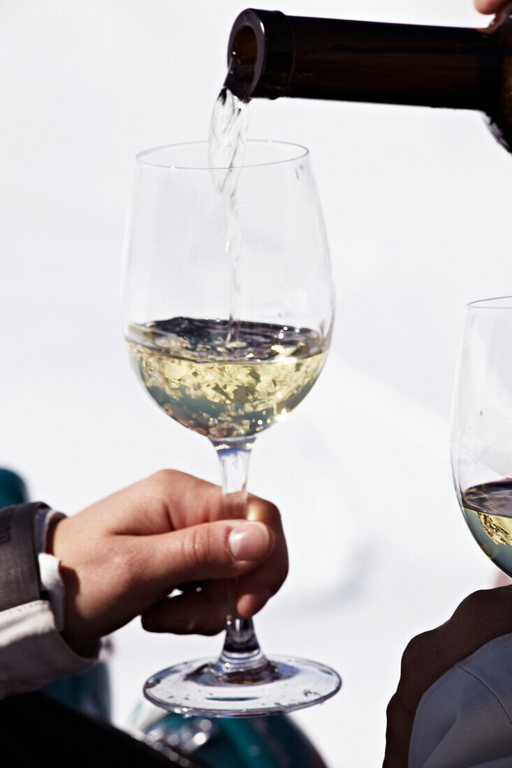 Pouring white wine into a wine glass in Zermatt, Switzerland