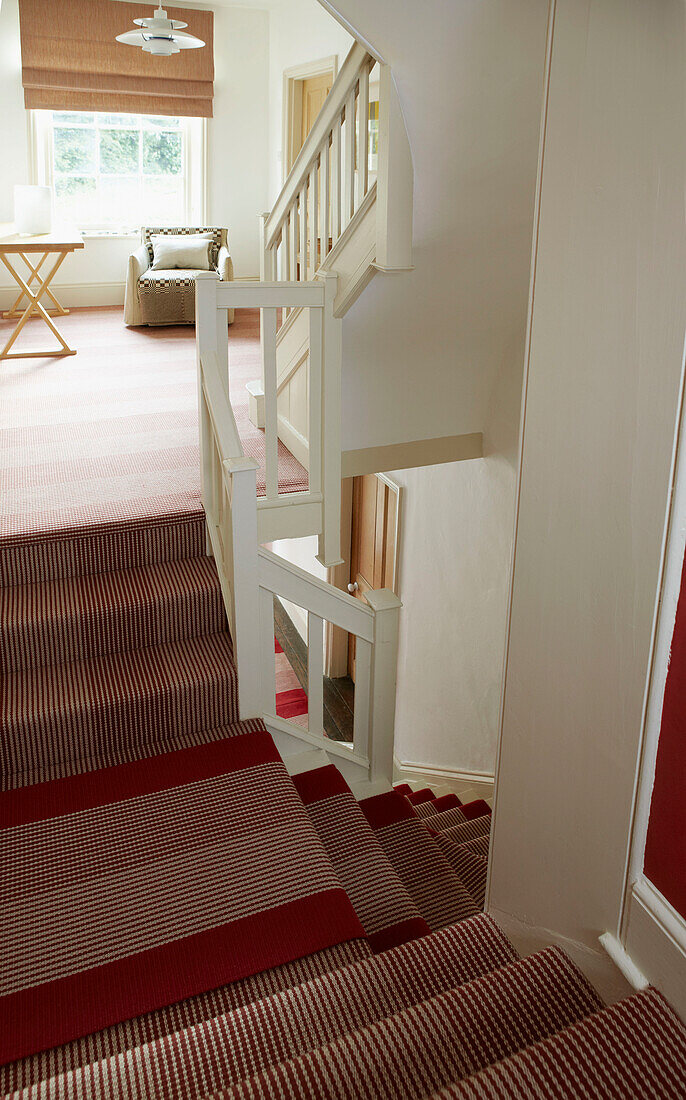 Upstairs hall stairs and landing with striped red carpet