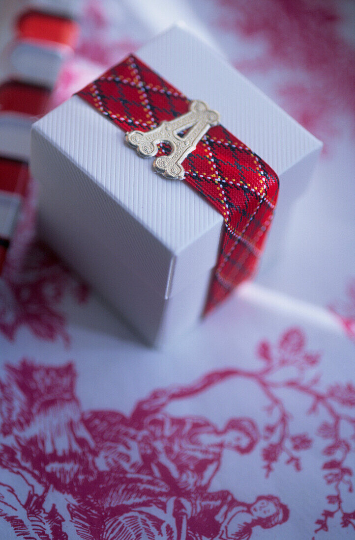 Gift box tied with ribbon with a foil letter