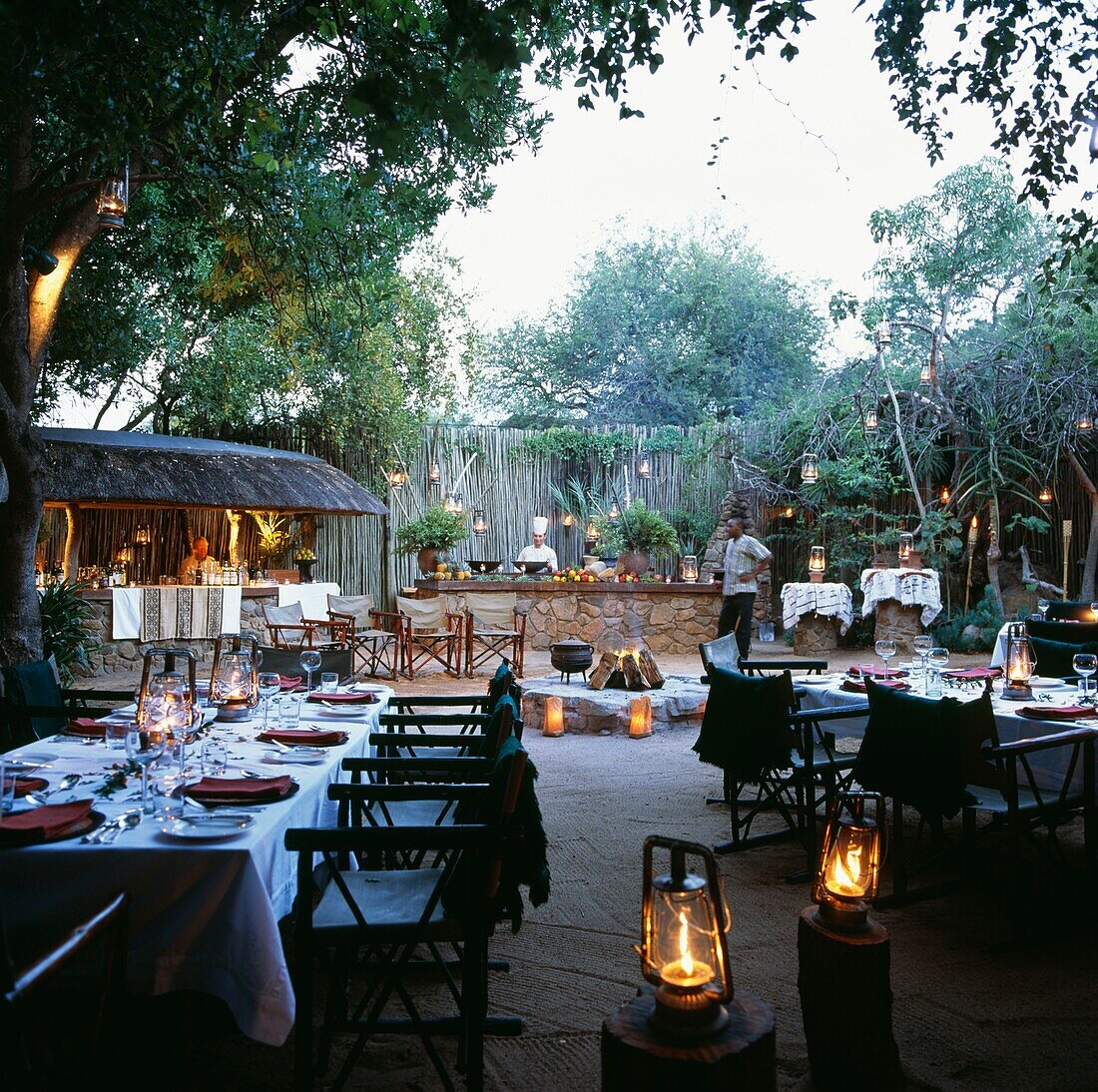 Essbereich im Freien mit gedeckten Tischen und Catering-Grill bei Singita in Südafrika