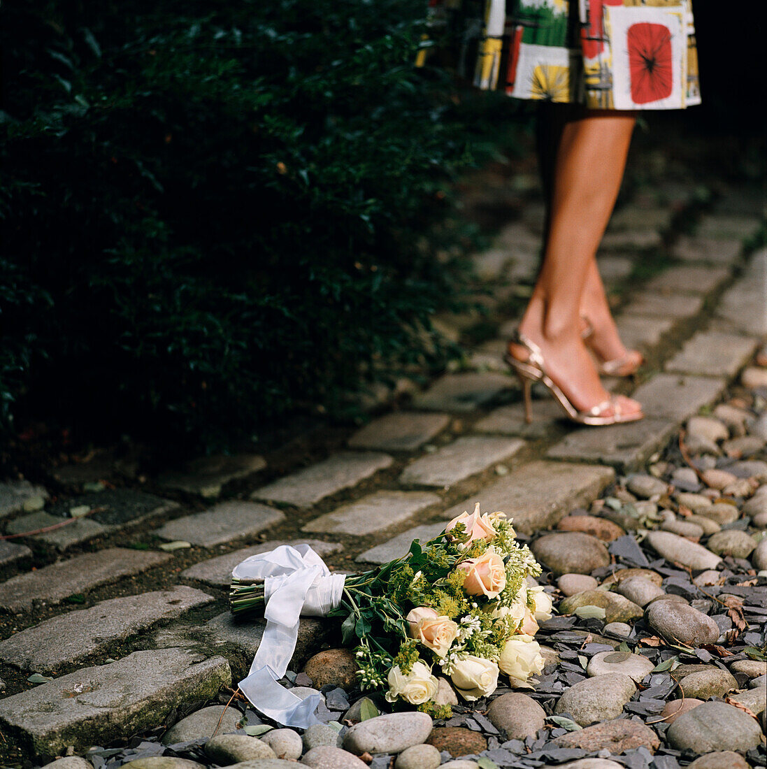 Woman walking away from bouquay of flowers on the ground