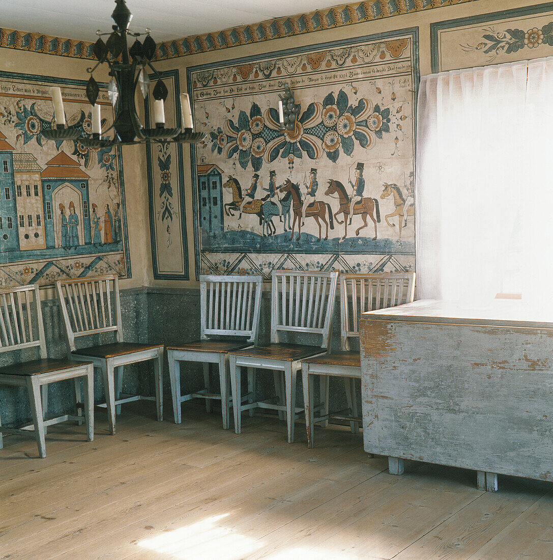 Painted frescoes and blue chairs in old Swedish interior