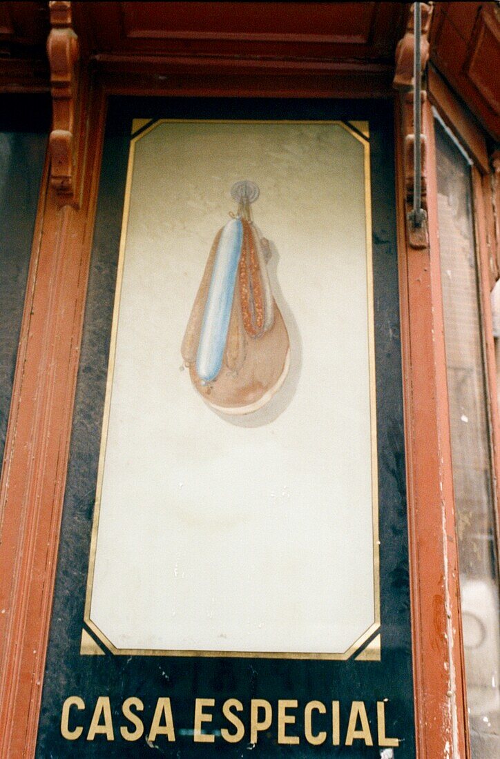 Painted sign of cured meats outside a delicatessen in Madrid