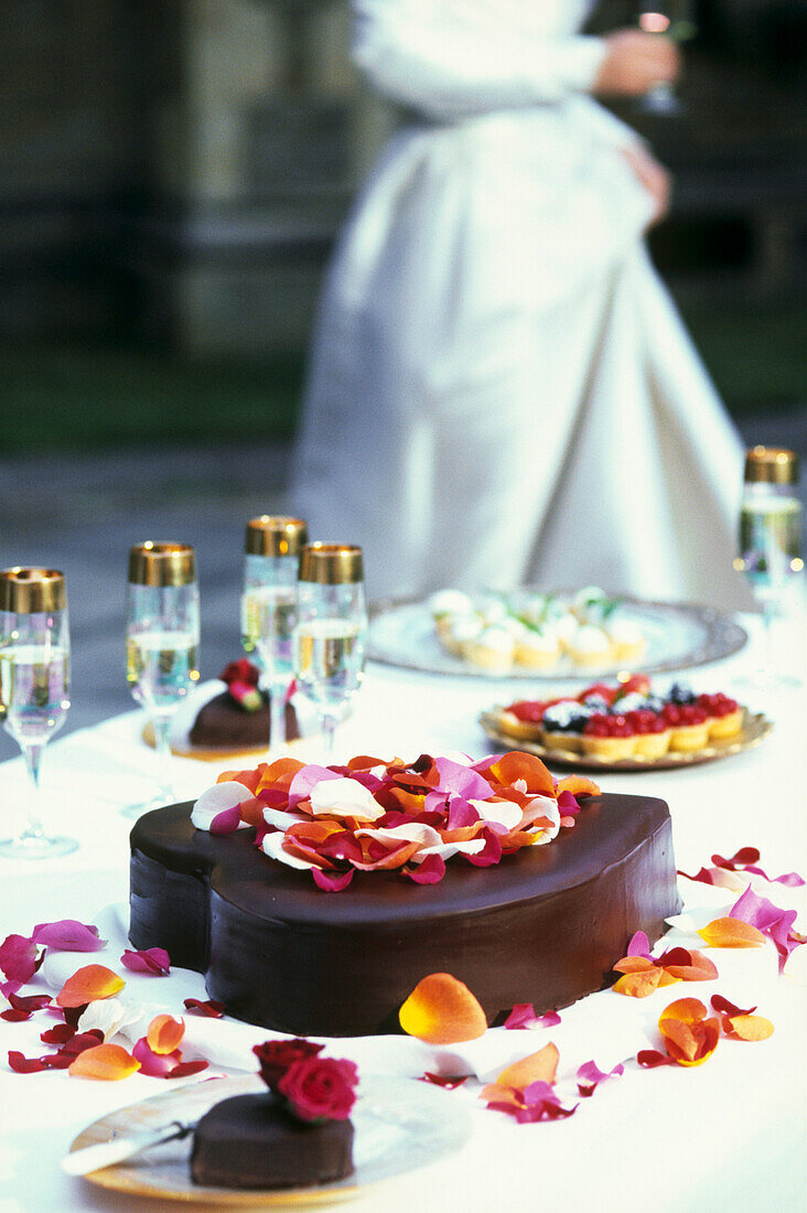 A heart-shaped chocolate wedding cake topped with rose petals