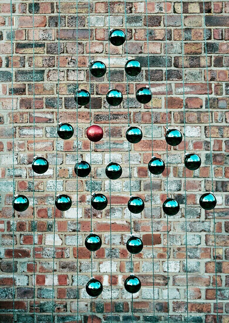 Art installation hanging against brick wall