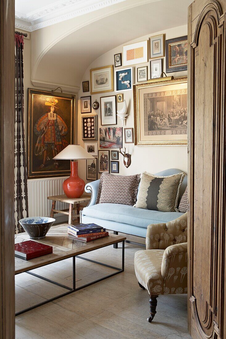 View through carved doorway to artwork display in London living room   UK