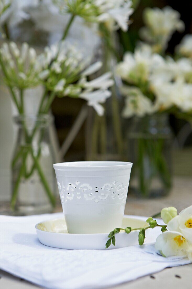 White candle holder and cut flowers on garden table   London   UK