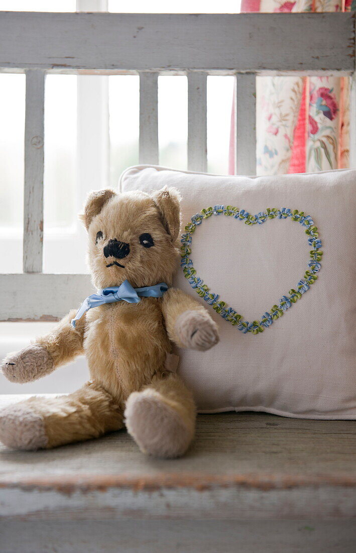Teddy bear with heart shape on cushion in child's room of Ashford home,  Kent,  England,  UK