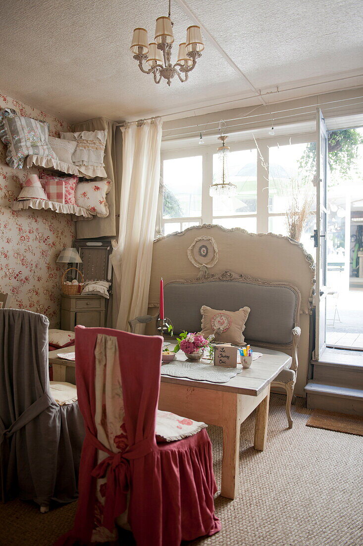 Slip covered chairs with wooden table at window of tea salon in Dordogne,  France