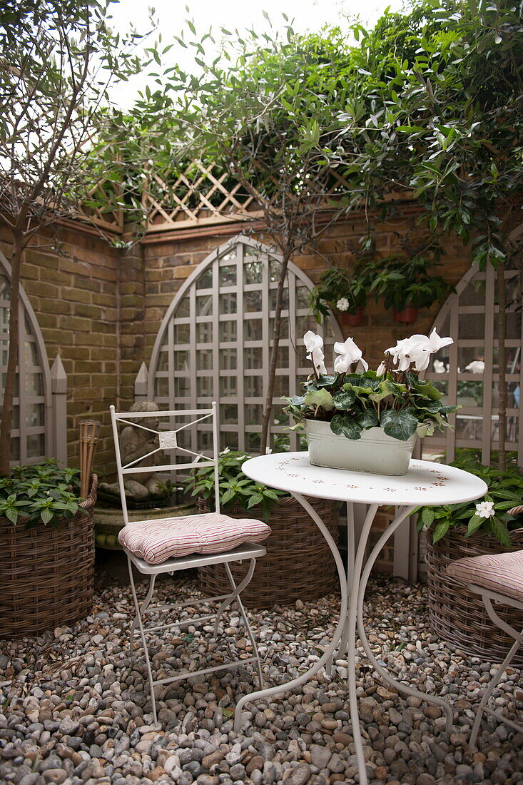 Folding chairs and table in courtyard garden of Battersea home,  London,  England,  UK