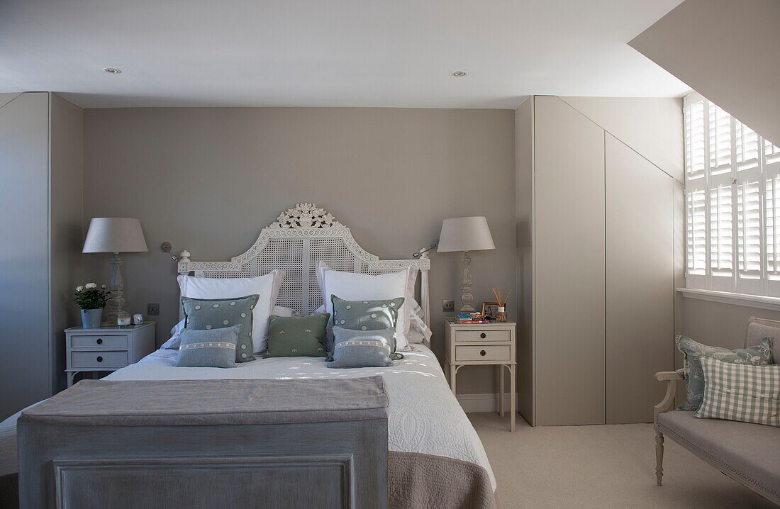 Doppelbett mit Kopfteil aus Korbgeflecht in einem Raum mit verborgenem Stauraum in einem Haus in Battersea, London, England, UK