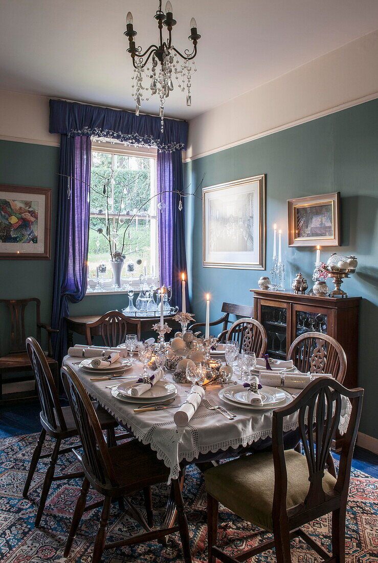 Lit candles and Christmas crackers on dining table in Tiverton farmhouse  Devon  UK