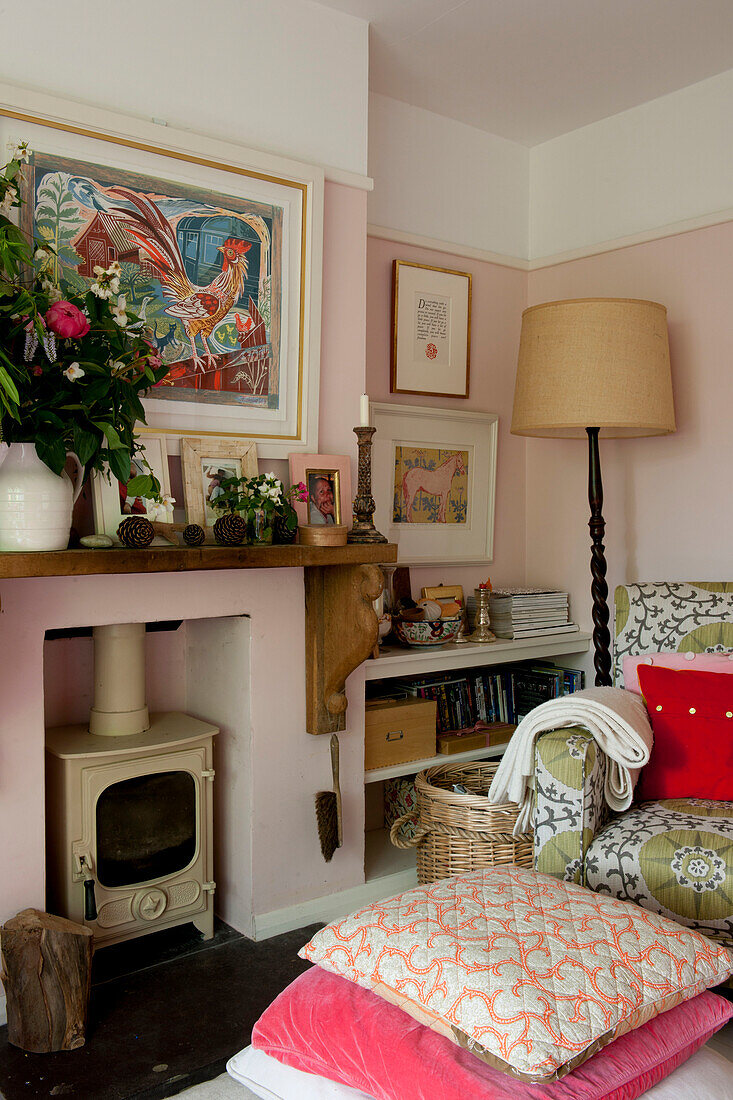 Armchair and woodburner with floor cushions in living room of contemporary Lewes home,  East Sussex,  England,  UK