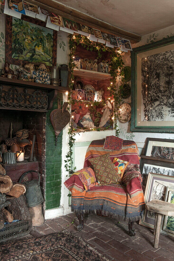 Armchair at fireplace in corner of Benenden cottage,  Kent,  England,  UK