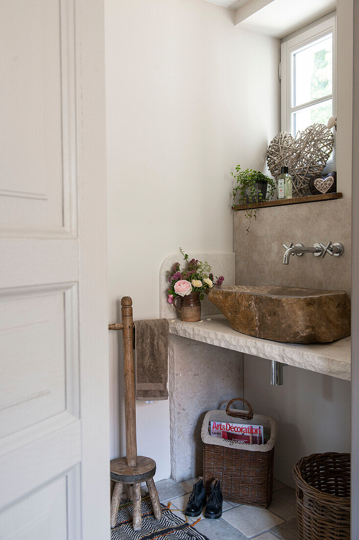 Stone washbasin at window with wicker baskets in Dordogne farmhouse  Perigueux  France