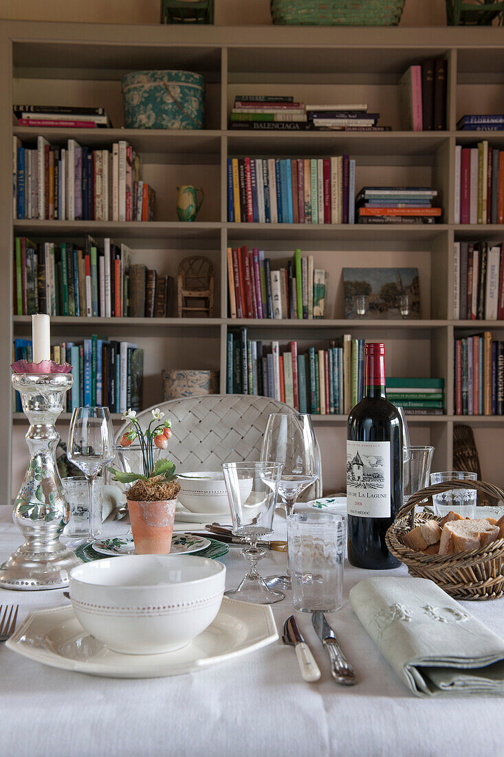 Red wine on dining table with bookcase in Dordogne cottage  Perigueux  France