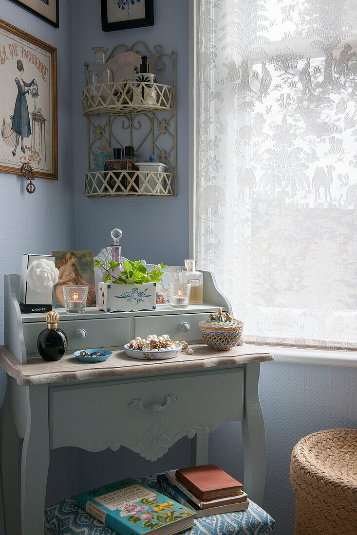 Toiletries on upcycled dressing table with lace curtain in London bedroom  England  UK