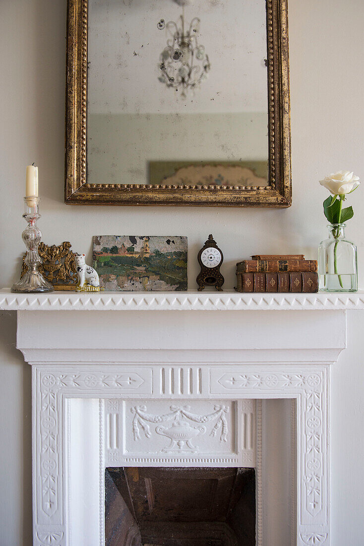 Gilt-framed mirror and ornaments on mantlepiece in East Barsham cottage  Norfolk  England  UK