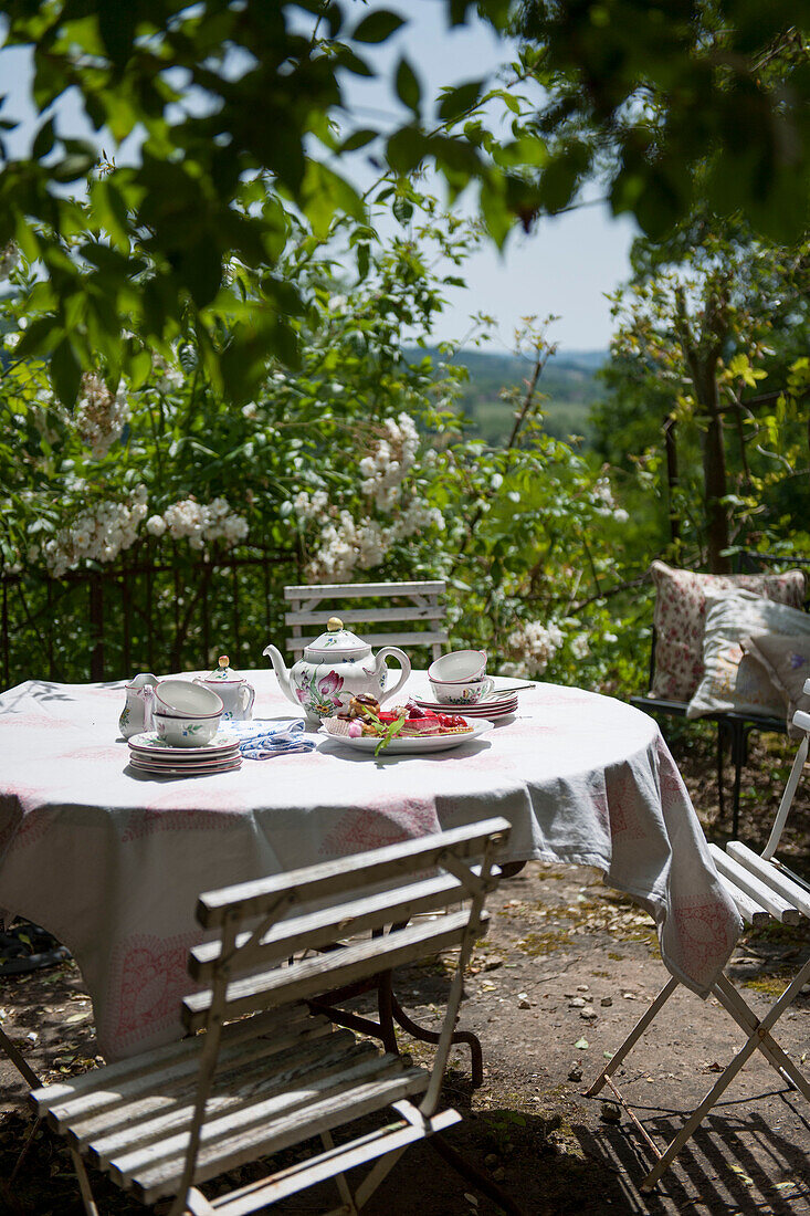 Teapot and cups on sunlit patio terrace in the Dordogne  France