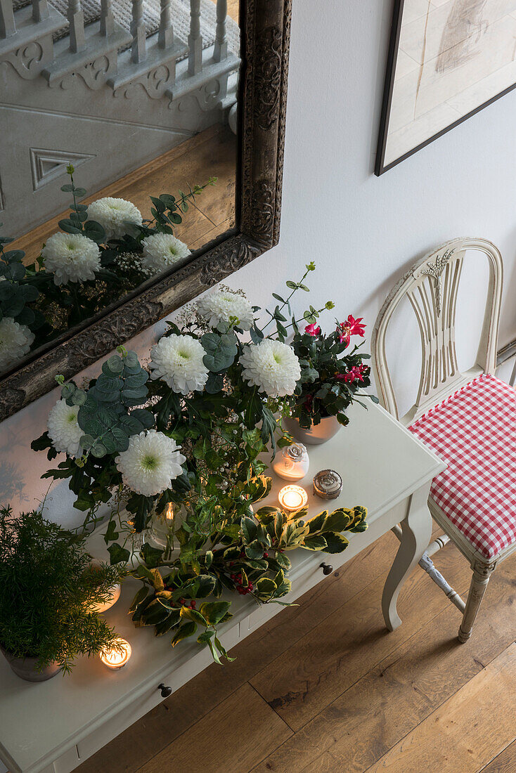 Cut flowers and tealights on hall table with mirror in North London Victorian house  England  UK